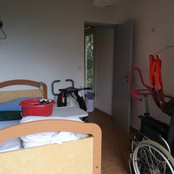 Chambre pédagogique avec lit médical et matériel professionnel (lève malade, verticalisateur, fauteuil roulant...)